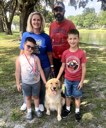 A family posing for a picture with their dog.